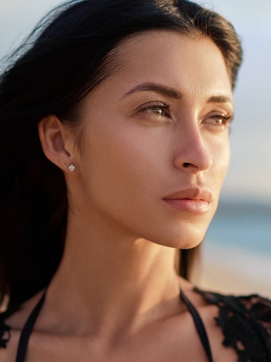 Woman gazing thoughtfully at the beach.
