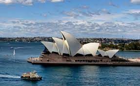 Sydney Opera House with boats on water.