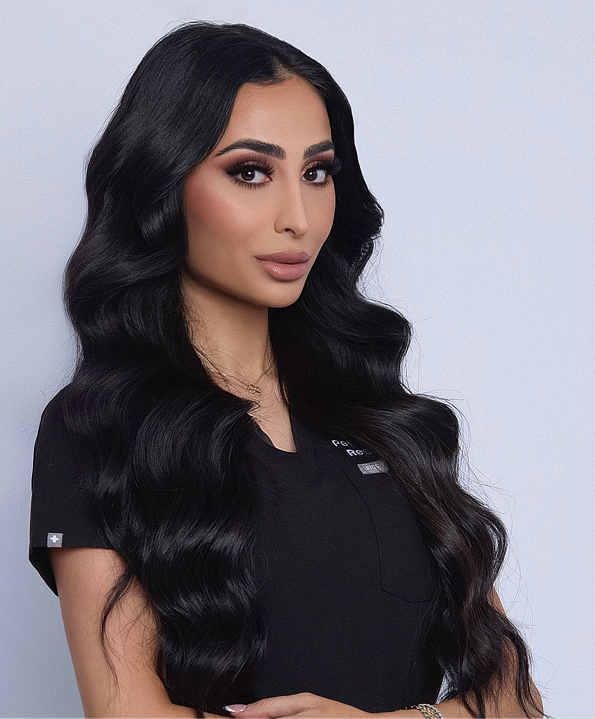 Woman with long, wavy hair in black outfit.